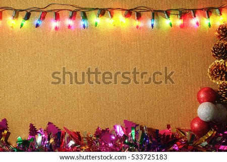 Christmas lights border with Christmas decoration on wooden background.                              