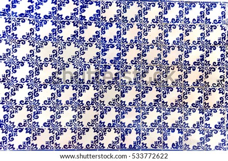 Horizontal photo in color of a ceramic tiles wall with blue figures delineated