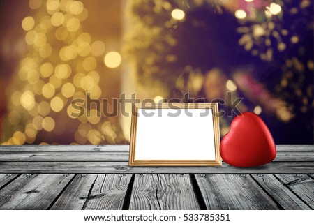 Red heart and wood frame on wooden table with christmas light night,abstract circular bokeh background