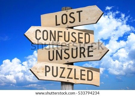 Wooden signpost with four arrows - lost, confused, unsure, puzzled. Royalty-Free Stock Photo #533794234