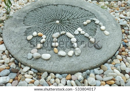 Flat lay of numeric 2017 year created by placing small stones on ground cement block with leaf pattern and grass ground in home garden for celebration new year festival