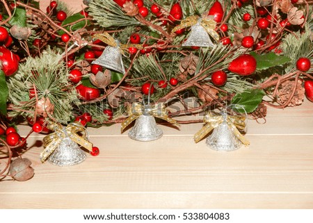 Christmas bells on the background of fir branches with red berries