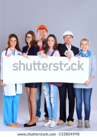 Portrait of smiling people with various occupations holding blank billboard