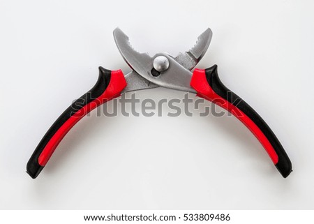 Red and black steel pliers on the white background 
