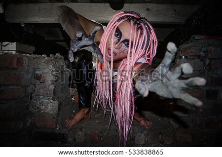 Girl with pink dreadlocks in a terrible basement