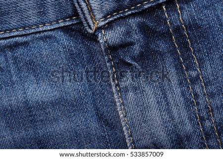 Denim jeans texture background with torn. The texture of the colored cotton fabric. Stitched texture jeans background.  Fashion jeans button. Pocket and rivet on jeans. Fiber and fabric structure.