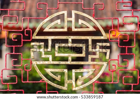 Stylized chinese characters made into a round vietnamese symbol for blessings like happiness, luck and longevity in front of a temple in Hoi An, Vietnam