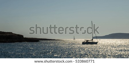 Sailboat against a background of the solar path. Mediterranean Sea. Summer.