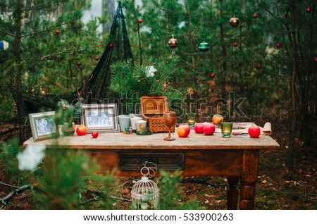 an old table stands in the woods around the Christmas tree decorated with toys on the table are various Christmas decor