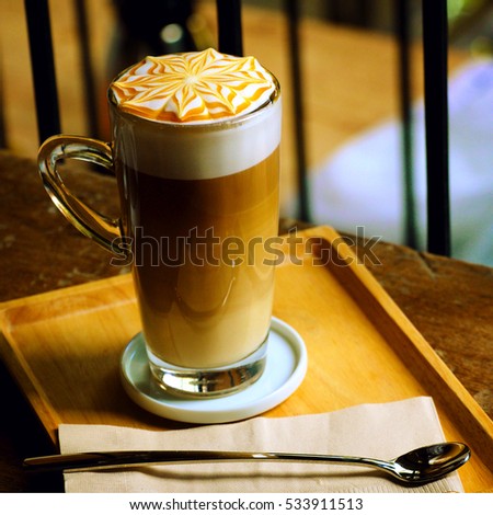 Macchiato coffee is an espresso coffee drink with a small amount of milk, usually foamed. In Italian, macchiato means "stained" or "spotted" . It is on wooden table in cafe.