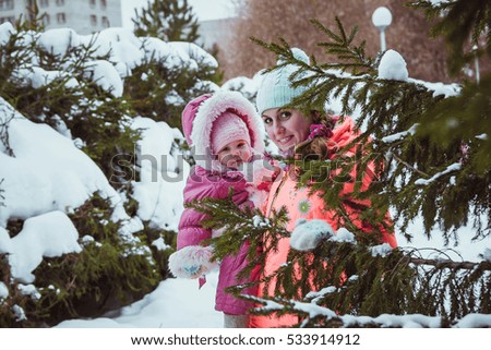 happy family mother and baby girl daughter in winter outdoors