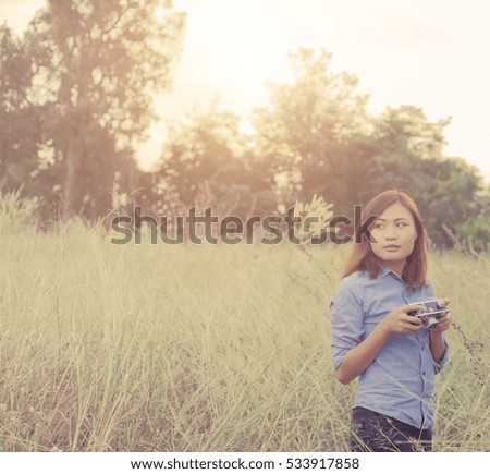 Vintage camera in woman hand on field