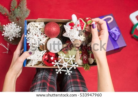 female holding an opened christmas  decoration box in pyjamas