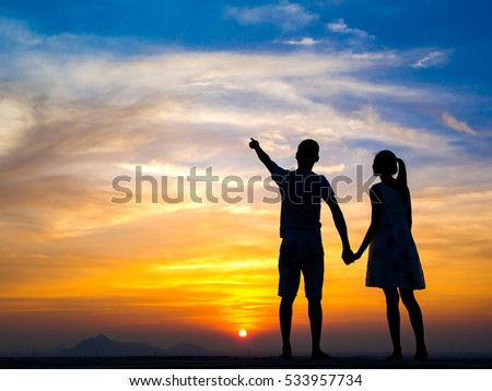 Silhouette of Happy Young Couple love Outside at Sunset
