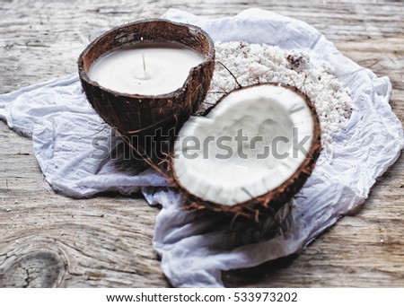 Homemade fresh hand traditional hand pressed coconut milk in a coconut bowl with slight drop of coconut milk and a half of coconut. Healthy ingredients. Wooden background/ white linen table cloth.  Royalty-Free Stock Photo #533973202