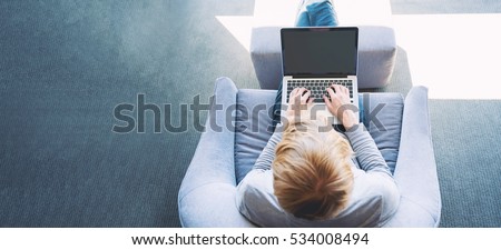 Man on a laptop in a modern brightly lit room Royalty-Free Stock Photo #534008494