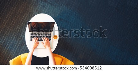 Person working on a laptop computer in a modern room Royalty-Free Stock Photo #534008512