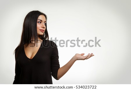 Beautiful Woman Holding Something. Young Female Pointing to Empty Space Royalty-Free Stock Photo #534023722