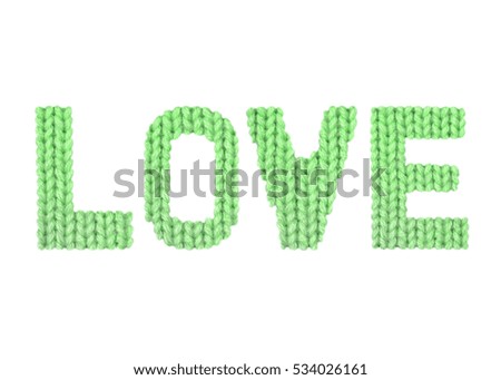 Love word on a blurry texture knitted pattern of woolen thread closeup. English alphabet. Typography design. Color green
