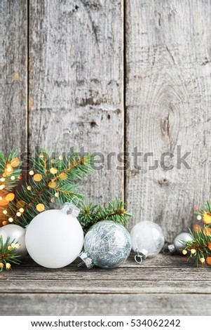 Silver and white christmas ornaments, xmas tree on rustic wood background with sparkle bokeh lights. Merry christmas greeting card. Winter holiday theme. Happy New Year. Space for text