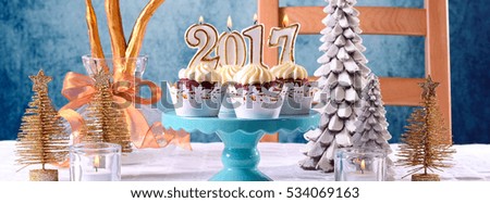  New Year 2017 cupcakes on a modern stylish, festive, blue gold and white Winter theme table setting, sized to fit a popular social media cover image placeholder.