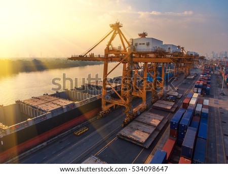 Container ship in export and import business and logistics. Shipping cargo to harbor by crane. Water transport International. Aerial view Royalty-Free Stock Photo #534098647
