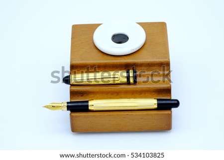 Fountain pen and inkwell over white background
