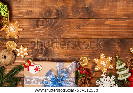 Christmas background with gifts, cookies, decor and fir tree branch on wooden table. Top view, with free space for you text.