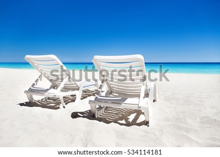 Sunbeds on tropical sandy beach. Vacation on the sea
 Royalty-Free Stock Photo #534114181