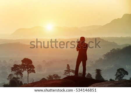 Viewing and capturing photo of sunlight at mountains and sky with mist in foggy.