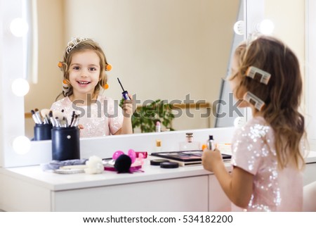 beautiful little girl in the mirror preening. little beauty