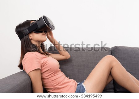 Woman sitting on sofa and viewing with VR device