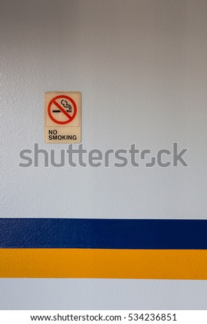 No smoking sign with blue and yellow striped on the wall