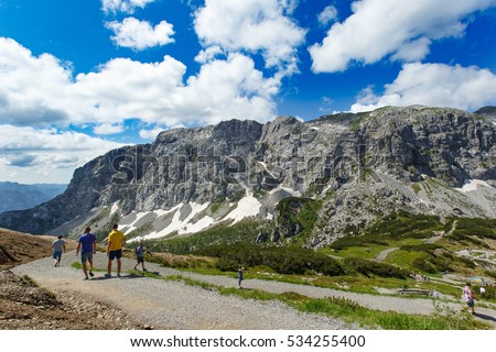 Panoramic view of Alps mountains in summer. Great view of beautiful landscape. Blue sky with clouds, green meadows, tourists on hiking trails. Nassfeld, Hermagor. Carinthia. Austria.