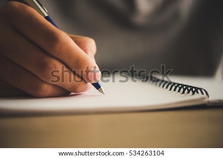 Man hand with pen writing on notebook.
 Royalty-Free Stock Photo #534263104