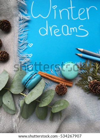 Shabby winter dreams.  Winter dreams. List for your winter dreams. Dreams, macaroons and pencils. rustic grey blanket with space for your text. 