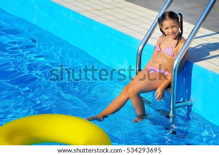 Real toddler girl relaxing at swimming pool, summer vacation concept