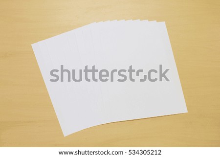 The white paper on the wooden table.