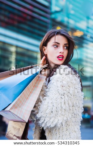 Portrait of fashion girl with shopping bags in the city