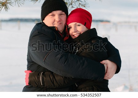 Young couple hugging and smiling at winter park