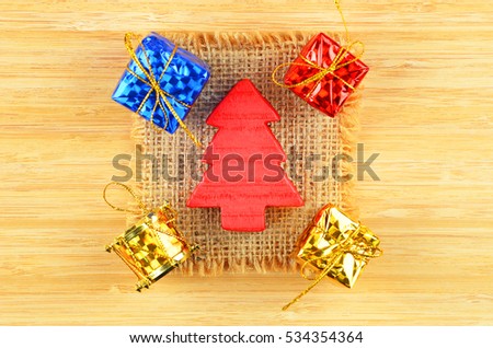 Decorative Christmas fir tree and gift on wooden background