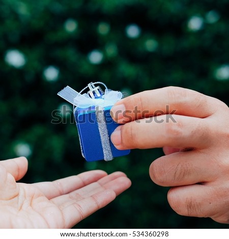 Closeup picture of man and woman's hands with Christmas gift box