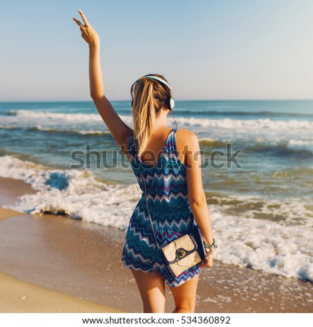 Pretty traveler woman ,listening music,  dancing , walking, enjoying holidays. Looking  on the sea. 