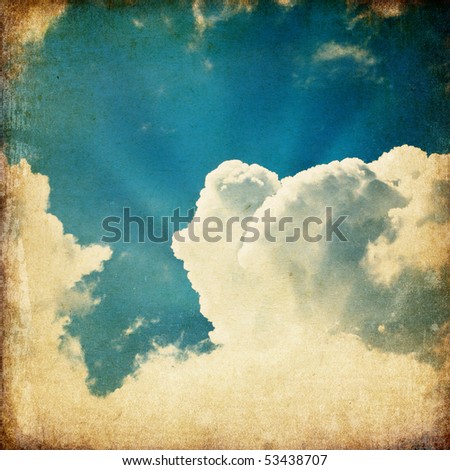 Clouds and a blue sky with a sun-rays shining through, useful as background element in design-works.