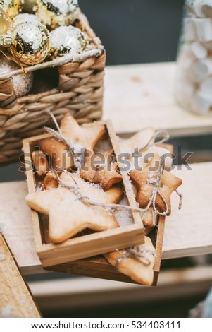 Christmas street decorations with star shaped cookies, cacao in cozy mugs, handmade wooden table, gingerbread in wooden boxes