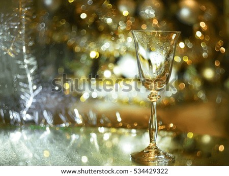 champagne glass and golden bokeh glowing sparkling lights and Christmas garland, Christmas.
