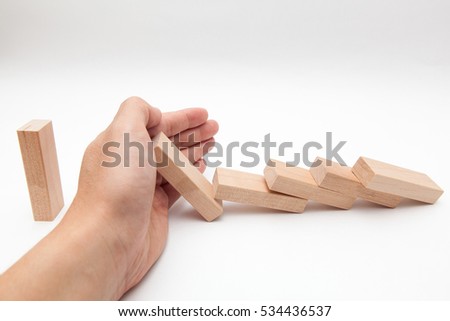 hand stop collapsing wooden block on white backgrounds Royalty-Free Stock Photo #534436537