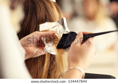 hairdresser coloring hair in studio Royalty-Free Stock Photo #534447844