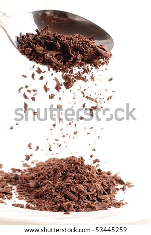 bits of chocolate in spoon isolated on white