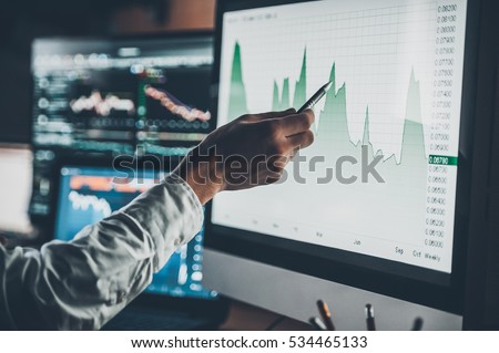 Analyzing data. Close-up of young businessman pointing on the data presented in the chart with pen while working in creative office  Royalty-Free Stock Photo #534465133